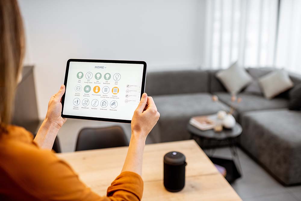 Young woman controlling home with a digital touch screen panel. Concept of a smart home and mobile application for managing smart devices at home