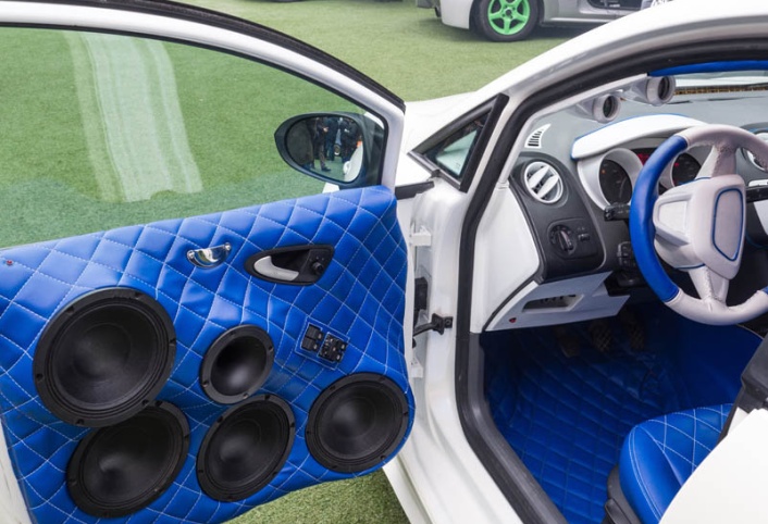 What’s Missing in Your Commute? How a High-End Car Audio System Changes Everything; white car with interior upholstered in blue leather and powerful stereophonic system