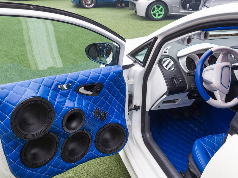 What’s Missing in Your Commute? How a High-End Car Audio System Changes Everything; white car with interior upholstered in blue leather and powerful stereophonic system