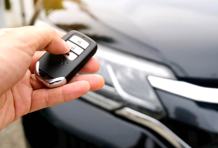 Ready to Beat the Weather? The Comfort of a Remote Car Starter Explained; Man hand holding the car remote, he push the remote control to open the car door