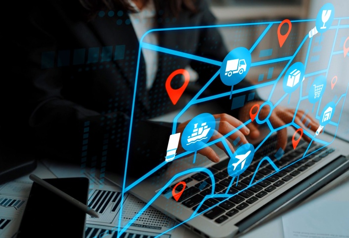 Hands typing on laptop with supply chain logistics icons